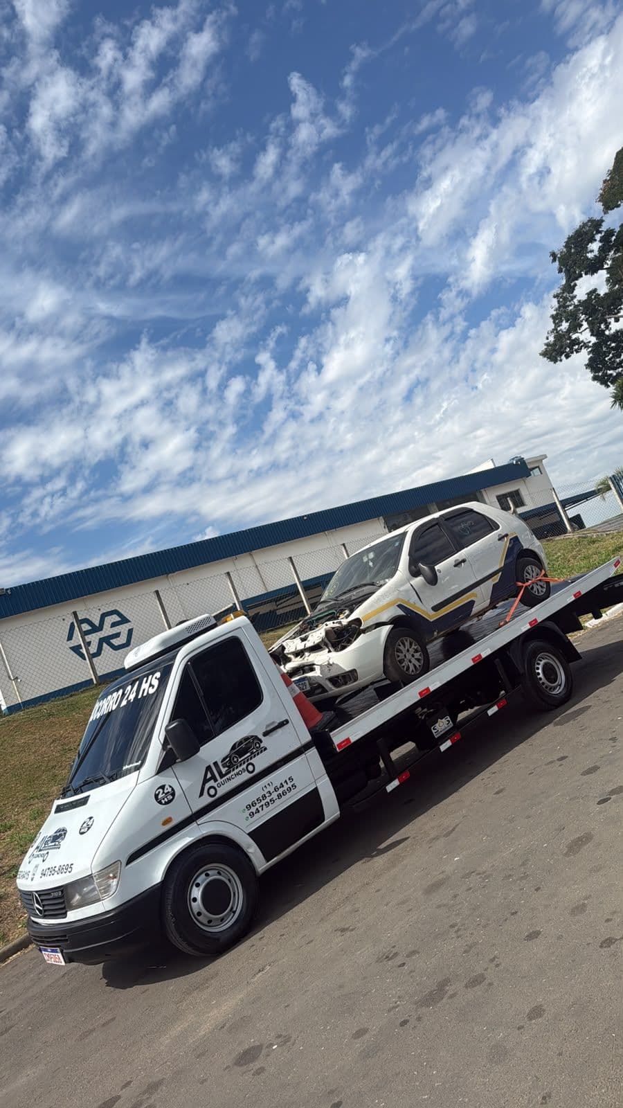 Caminhão plataforma da AL Guinchos transportando um carro