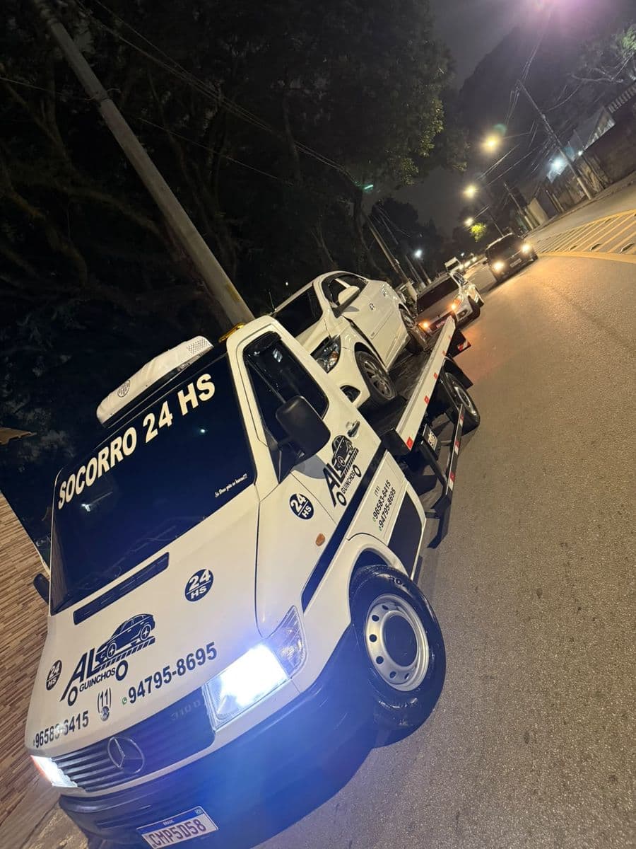 Caminhão do socorro 24h da AL Guinchos à noite com faróis acesos