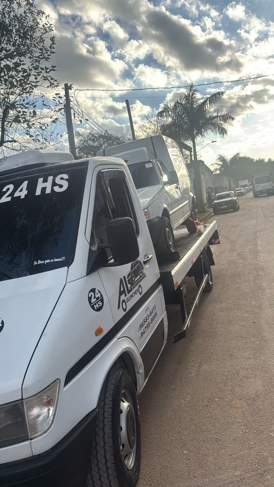 Guincho plataforma AL transportando veículo em via de São Paulo